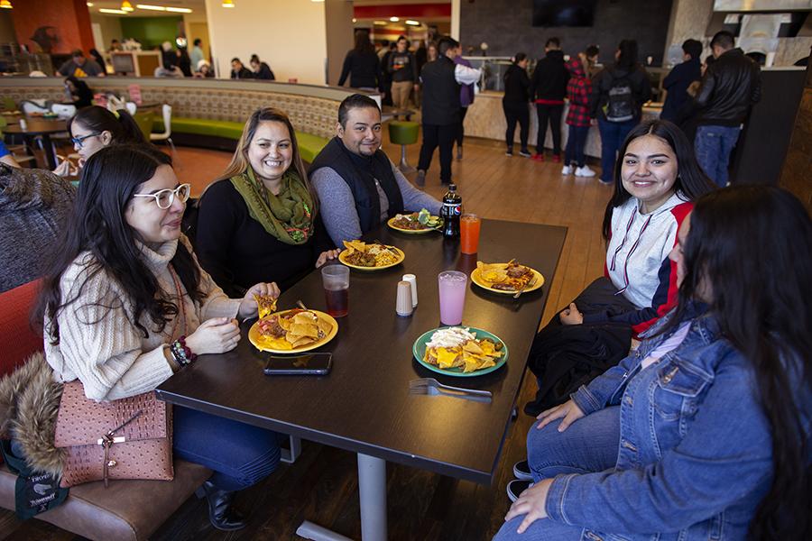 una familia hispana come en un comedor universitario.