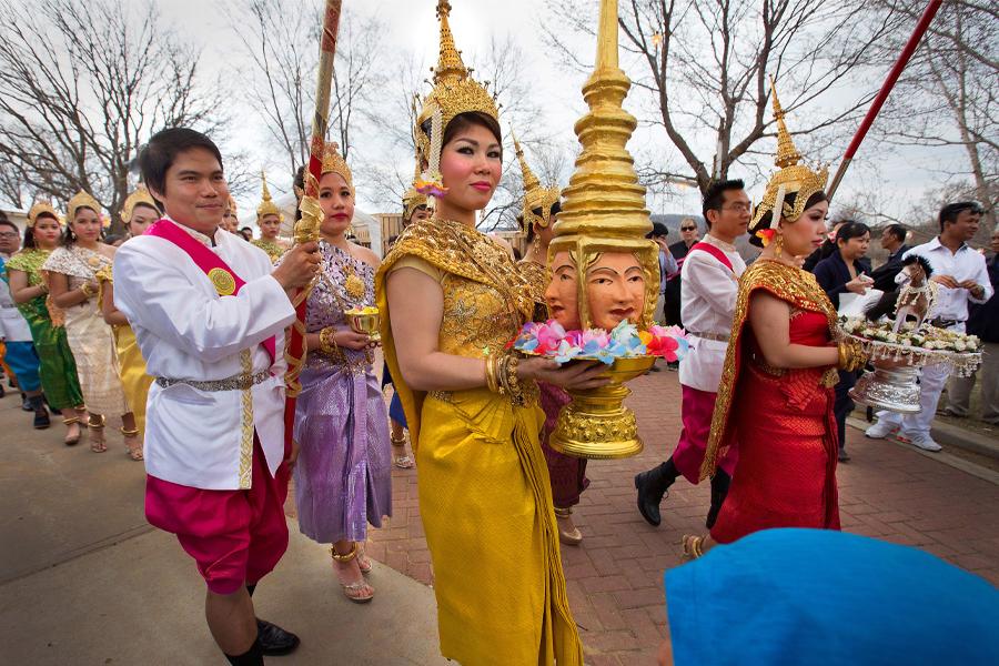 A woman dressed in gold is part of a procession during during Khmer New Year celebration in Southeast Asia.