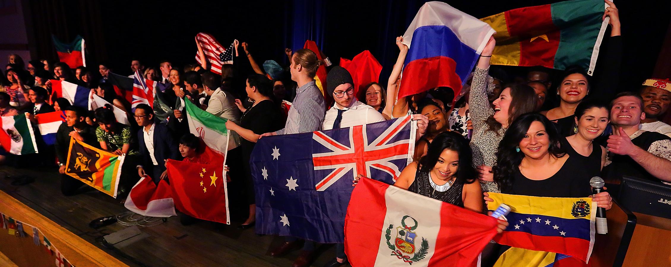 一大群学生举着世界各国的国旗.