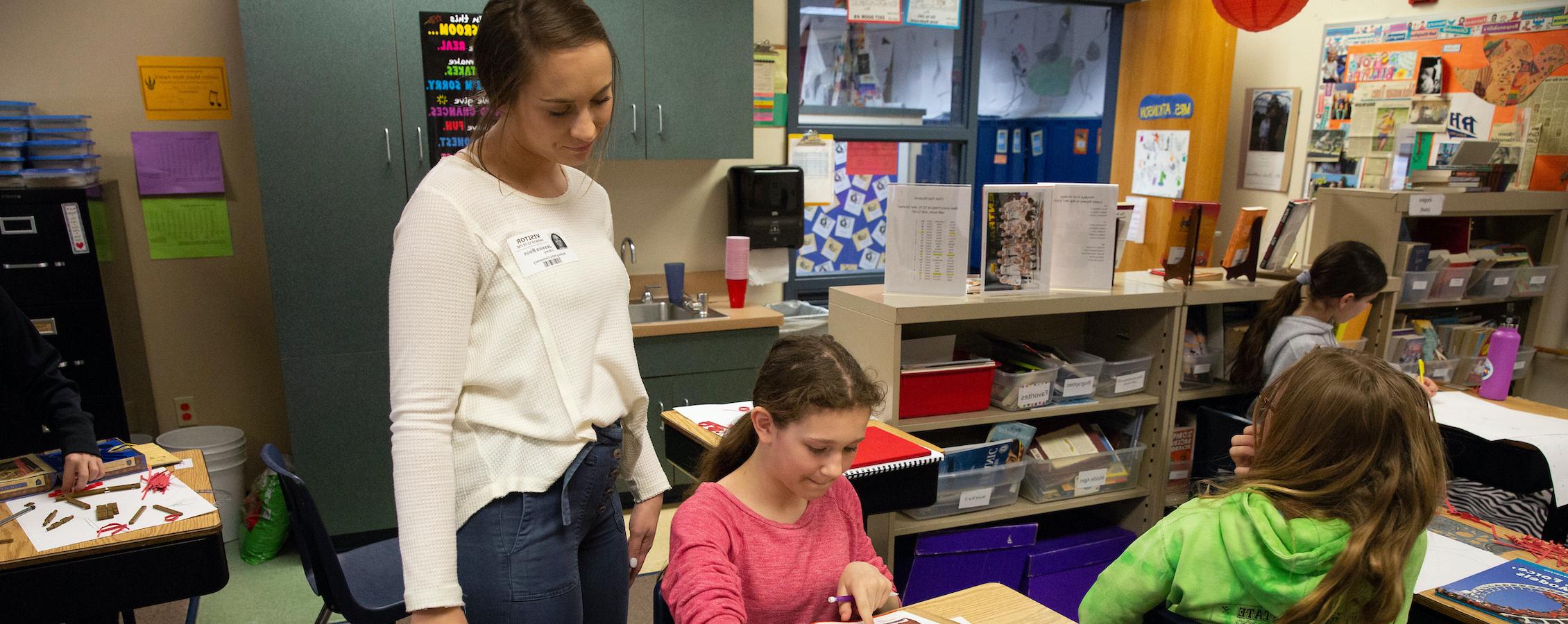 Education student Jessica Boos works on a science lesson with elementary school children.