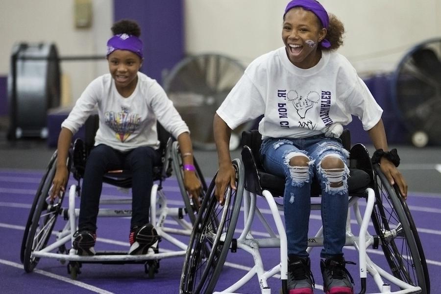 两个十几岁的女孩在家庭聚会上玩轮椅篮球.