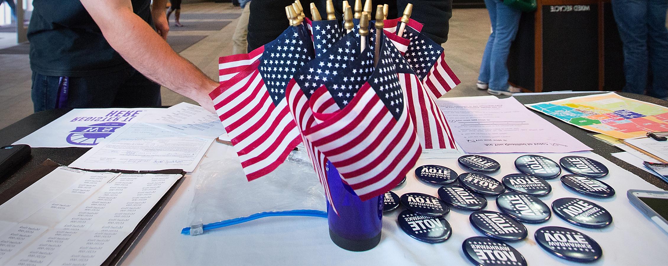 American flags and Warhawks Vote buttons sit on a table.